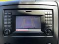 A dashboard display of a 2017 Mercedes-Benz Sprinter showing a rearview camera view with grid lines and a warning to check surroundings