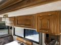 Interior view of a 2000 Ford motorhome featuring wooden cabinets with gold handles and a light fixture hanging below the cabinets