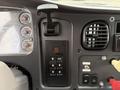 The dashboard of a 2005 Freightliner M2 106 featuring a gear shift lever with buttons for drive modes and various gauges for speed and fuel levels