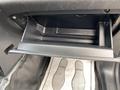 A black glove compartment of a 2021 Ford Explorer with a textured surface and a flat bottom drawer without contents