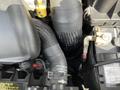 A close-up view of a 2005 Chrysler PT Cruiser engine with various hoses and components including a black flexible hose and metal fittings