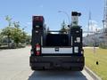 A 2023 Ford F-550 truck with a flatbed equipped with various tools and equipment visible on the rear including a generator and a hoist