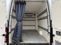 A 2016 Mercedes-Benz Sprinter with an open rear door revealing a spacious cargo area and a curtain hanging from the ceiling