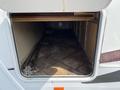 A 2013 Outdoor Wind River with an open storage compartment revealing tiled flooring and some visible equipment including chains and tools