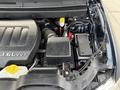 A 2013 Dodge Journey engine compartment showcasing a V6 engine with various components like the air intake battery and fluid reservoirs