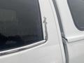 A close-up of the driver's side rear window of a 2015 GMC Sierra 1500 showing a section of peeling paint near the edge of the window frame