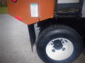A 2016 International WorkStar 7500 showing a close-up of the rear wheel and mud flap with a safety instruction label visible on the truck's body