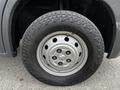 A close-up view of a tire mounted on a 2018 RAM Promaster showing a silver steel wheel with a textured black tire tread