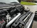 A close-up view of the engine compartment of a 2005 GMC C5 Duramax showcasing various components including hoses and a large air intake system