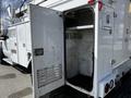 A 2008 Ford F-550 service truck with an open side compartment revealing a shelf and a clean interior space