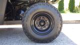 Close-up of a 2016 Polaris Ranger 570 Crew tire showcasing its rugged tread and black rim