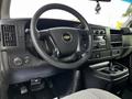 Interior view of a 2015 Chevrolet Express showing the steering wheel dashboard and control panel with cup holders