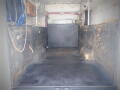 2005 Ford F-750 with an empty cargo area featuring black flooring and walls showing wear and dirt stains