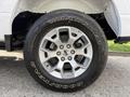 A close-up of a silver alloy wheel with a Goodyear Wrangler tire showcasing the Ford logo and a bold tread design