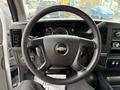 The image shows the steering wheel of a 2013 Chevrolet Express with a black leather cover and the Chevrolet logo at the center