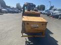 A yellow 2010 Trackless MT6 with a front-mounted attachment facing forward
