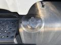 Close-up of a metal fuel cap on a 2015 Freightliner M2 106 with an engraved warning label and textured surface