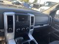Interior view of a 2011 RAM 1500 dashboard featuring a digital clock audio controls and a gear shifter