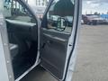 A 2004 Ford Econoline with an open side door showing the driver's seat and interior controls