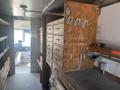 Interior of a 2007 Morgan Olson Workhorse W42 featuring wooden cabinets and drawers along one side with a countertop and workspace area