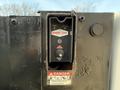 A control panel for a Tommy Gate hydraulic lift mounted on a vehicle with a power switch and buttons for lift operation