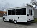 A white 2016 Ford Econoline shuttle bus with large side windows and a wheelchair lift on the rear