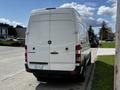 A white 2012 Mercedes-Benz Sprinter van viewed from the rear showing the brand logo and model name on the back door