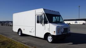 A 2009 Ford Econoline cargo van with a white exterior and no visible logos parked at an angle showing the front and side of the vehicle