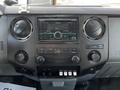 Dashboard of a 2011 Ford F-450 SD featuring a Kenwood stereo system with various control buttons and knobs alongside climate controls and auxiliary ports