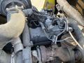 A close-up view of the engine components of a 2010 Kubota F3990 including pipes wires and a turbocharger