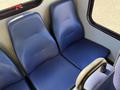 Two blue fabric seats in a vehicle interior with a textured surface and a visible armrest