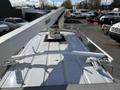 A white 2008 Ford Econoline van with a mounted lifting arm on the roof for utility work