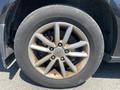 A close-up view of a wheel from a 2020 Dodge Grand Caravan featuring a silver multi-spoke alloy rim with some rust and a black tire with visible tread pattern