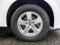 Close-up of a silver alloy wheel with five spokes mounted on a black tire on a 2011 Dodge Grand Caravan