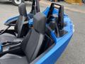 A 2020 Polaris Slingshot with two black seats and a blue exterior featuring prominent shoulder supports and a streamlined design