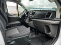 Interior view of a 2023 Ford Transit showcasing driver and passenger seats along with the dashboard and control panel