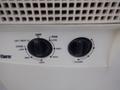 Close-up of control knobs on a white air conditioning unit showing settings for fan speed and temperature adjustment