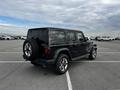 A black 2019 Jeep Wrangler parked in a lot showcasing its distinctive boxy shape and spare tire mounted on the rear door