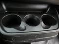 A close-up view of a black plastic cup holder with three circular openings designed to hold drinks in a 2017 Chevrolet Express