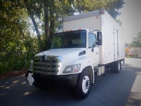 A white 2013 Hino 268 box truck with a silver cargo area and black front bumper facing forward