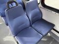 A pair of blue bus seats with a textured surface and armrest in between them