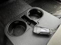 A key fob for a Ford vehicle rests on a black cup holder in a 2017 Ford F-250 interior