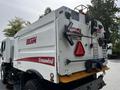 A white 2012 Autocar Xpert street sweeper with a red and white rear section displaying warning signs and an Elgin logo