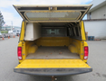 A yellow 2015 RAM 1500 truck with its tailgate down and canopy raised showing an empty cargo bed