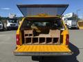 A yellow 2013 Chevrolet Silverado 1500 pickup truck with an open canopy revealing wooden storage compartments in the bed