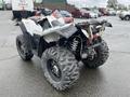 A 2017 Polaris Scrambler ATV with large knobby tires and a rear suspension system visible from the back angle
