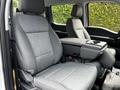 Interior of a 2024 Ford F-550 featuring two grey cloth seats with a center console between them