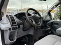 Interior view of a 2018 Ford Transit showing the steering wheel dashboard and control panel with seats and storage areas visible