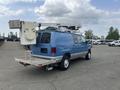 A blue 2010 Ford Econoline van with a lift mechanism mounted on the roof and a platform attached to the rear