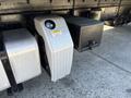 A silver fuel tank with a diamond plate design mounted on the side of a 2015 Freightliner M2 106 truck